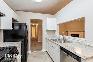 Riverdale house for rent - a kitchen with white cabinets and a sink and a refrigerator