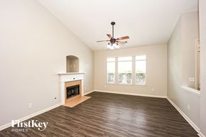 Fairburn house for rent - A spacious room with a fireplace and a ceiling fan.