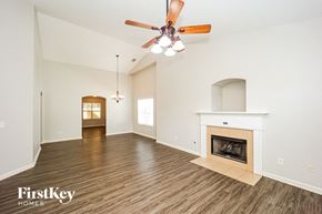 Fairburn house for rent - A spacious living room with a fireplace and a ceiling fan.