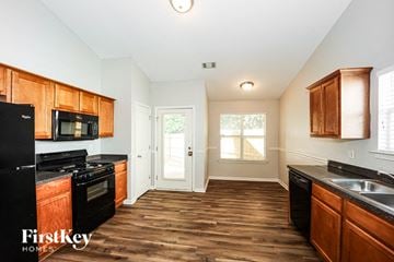 Fairburn house for rent - A kitchen with wooden cabinets and black appliances.