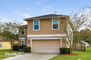 St. Augustine house for rent - a house with a garage door and a lawn