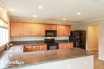 St. Augustine house for rent - a kitchen with wooden cabinets and a granite counter top