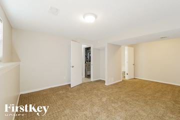 Raymore house for rent - a spacious living room with beige carpet and white walls