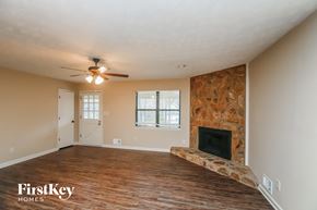Dallas house for rent - A room with a fireplace and a ceiling fan.