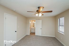Dallas house for rent - A spacious room with a ceiling fan and a carpeted floor.