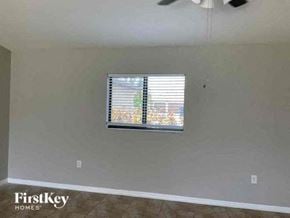Cape Coral house for rent - an empty living room with a window and a ceiling fan