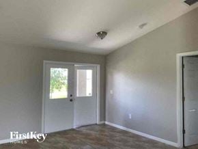 Cape Coral house for rent - an empty living room with a door and a window