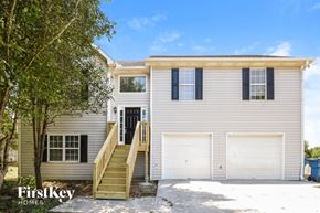 Adairsville house for rent - a white house with two white garage doors and a staircase