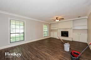 Mesquite house for rent - A room with wooden floors and a fireplace is ready for painting.