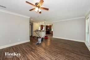 Mesquite house for rent - A room with a fan and wooden floors.