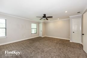 Mesquite house for rent - A spacious room with a ceiling fan and carpeted floor.