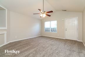 Mcdonough house for rent - A spacious room with a ceiling fan and a door leading to another room.