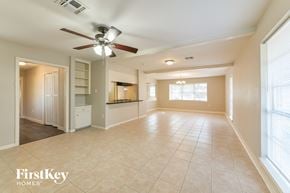 Spring house for rent - A spacious living room with a ceiling fan and tiled flooring.