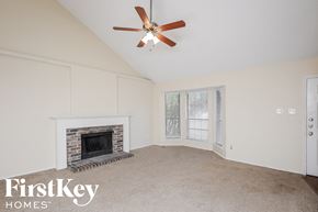 Keller house for rent - A room with a fireplace and a ceiling fan.