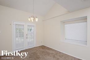 Keller house for rent - A room with a carpeted floor, a window with blinds, a door with a window, and a light fixture hanging from the ceiling.