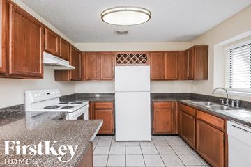 Keller house for rent - A kitchen with brown cabinets and a white refrigerator.