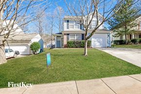 Charlotte house for rent - a home with a lawn and trees in front of it