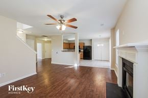 Charlotte house for rent - an empty living room with a fireplace and a ceiling fan