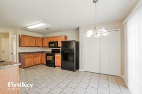 Charlotte house for rent - a kitchen with wooden cabinets and a black refrigerator