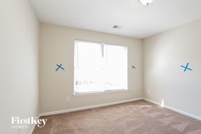 Charlotte house for rent - a bedroom with blue x marks on the wall and a window
