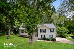 Douglasville house for rent - a white house with blue shutters and a yard with trees