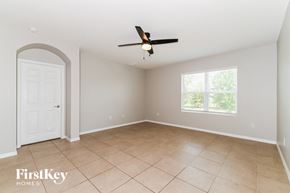 Cape Coral house for rent - A spacious room with a fan and a door.
