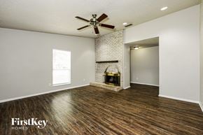 Mesquite house for rent - A room with a fireplace and a fan on the ceiling.