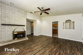 Mesquite house for rent - A room with a brick wall and wooden floors.