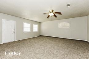Mesquite house for rent - A spacious room with a ceiling fan and two windows.