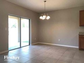 Cape Coral house for rent - an empty living room with a tile floor and a sliding glass door