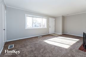 Park Forest house for rent - A room with a carpeted floor and a window letting in sunlight.