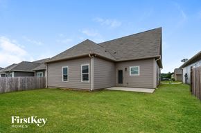 Calera house for rent - backyard and side view of a house with a yard and grass