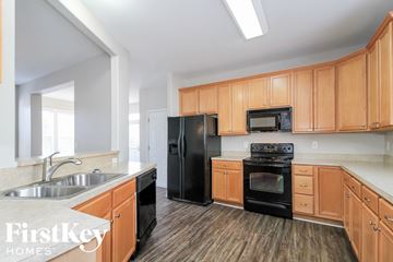 Bermuda Run house for rent - a kitchen with wooden cabinets and black appliances