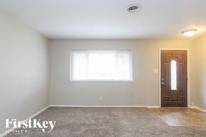 Beech Grove house for rent - A room with a carpet floor, a door, and a window.