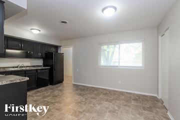 Beech Grove house for rent - A kitchen with black cabinets and a marble countertop.