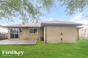 Beech Grove house for rent - A house with a brown brick exterior and a white garage door is for sale.