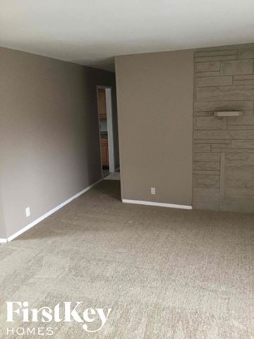 Indianapolis house for rent - a living room with a carpet and a stone wall