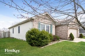 Greenwood house for rent - A house with a white siding and a brick chimney is for sale.