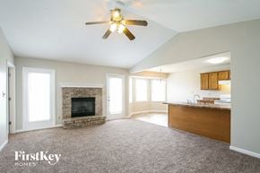 Greenwood house for rent - A spacious living room with a fireplace and a ceiling fan.