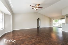 Cape Coral house for rent - an empty living room with wood flooring and a ceiling fan