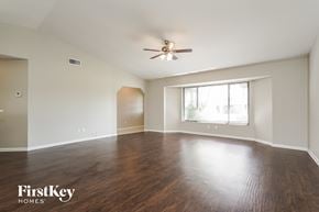 Cape Coral house for rent - an empty living room with wood floors and a ceiling fan