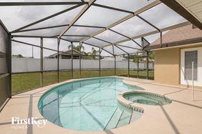 Davenport house for rent - a pool in a screened in area with a patio and a house