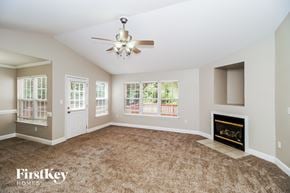 Concord house for rent - A spacious living room with a fireplace and a ceiling fan.