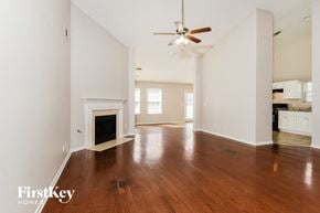 Powder Springs house for rent - A spacious living room with a fireplace and hardwood floors.