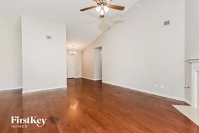 Powder Springs house for rent - A spacious room with wooden floors and a ceiling fan.