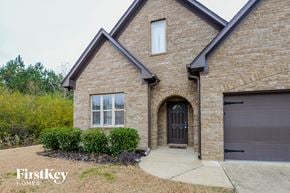 Odenville house for rent - front view of a brick house with a black garage door