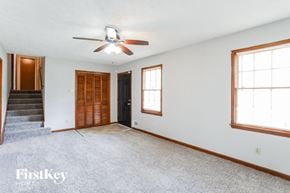 Stockbridge house for rent - an empty living room with a ceiling fan and a staircase