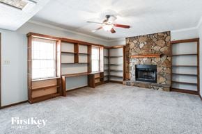 Stockbridge house for rent - a living room with a stone fireplace and book shelves