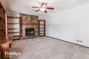 Stockbridge house for rent - a living room with a stone fireplace and a ceiling fan