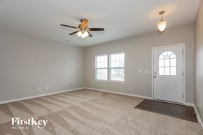 Troutman house for rent - a living room with a ceiling fan and a white door